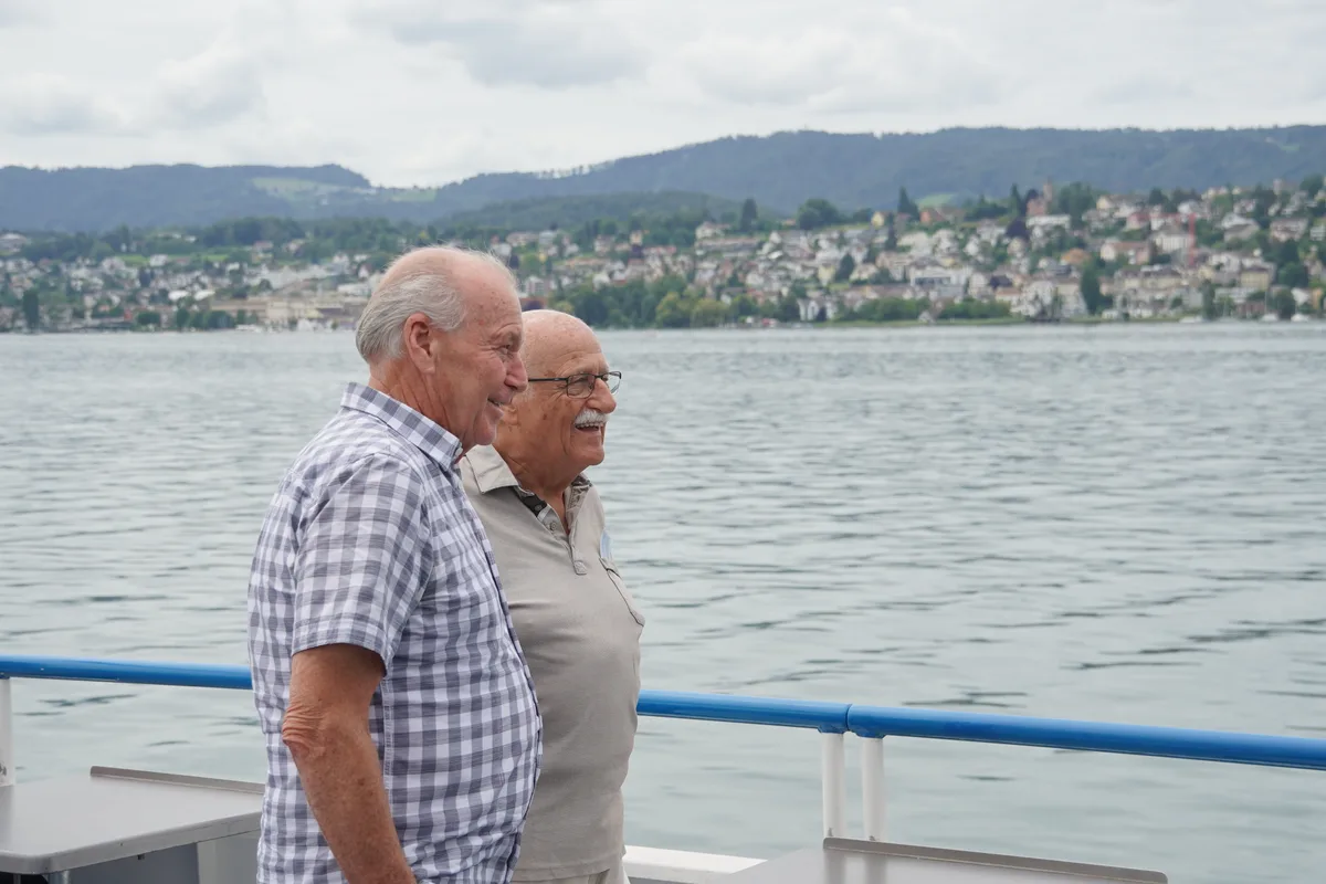 Zwei ältere Männer stehen auf dem Schiff und posieren für die Kamera.